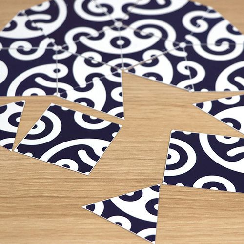 Close-up of a puzzle featuring traditional Japanese indigo and white wave pattern pieces spread across a wooden surface.