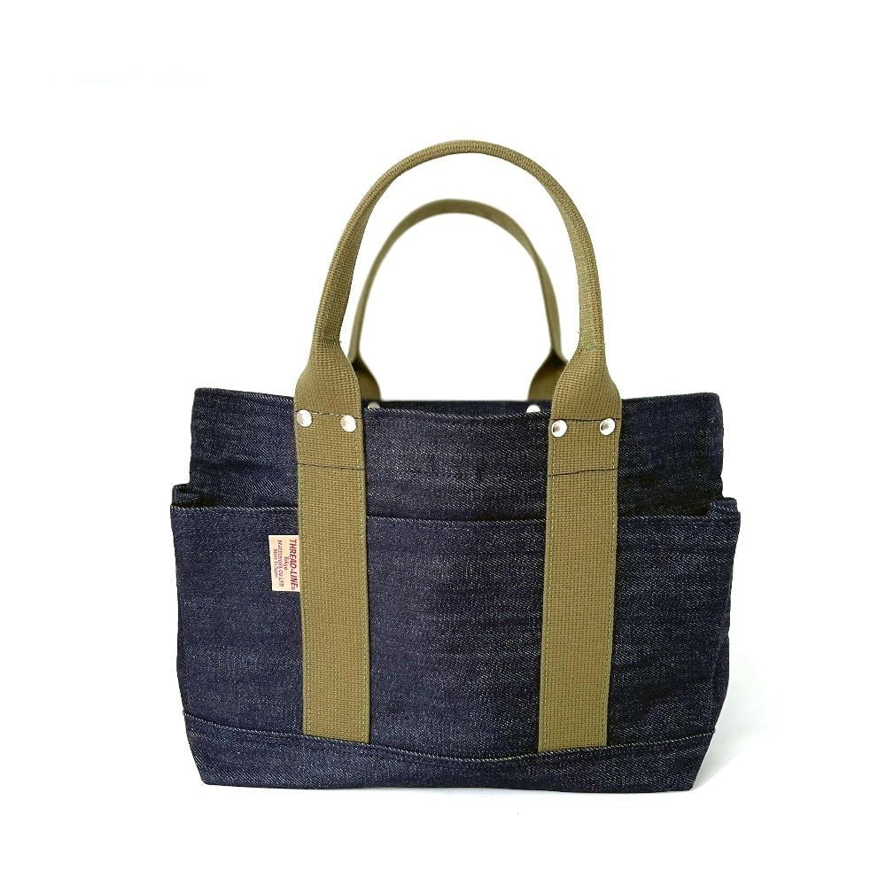 Studio photo of small Japanese selvage denim tote with olive green handles, side pockets, and front stitch detailing by Thread Line Tokyo