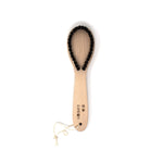 Japanese wooden lint brush with looped bristles for removing lint and pet hair from delicate fabrics, handcrafted in Asakusa by Kanaya Brush.