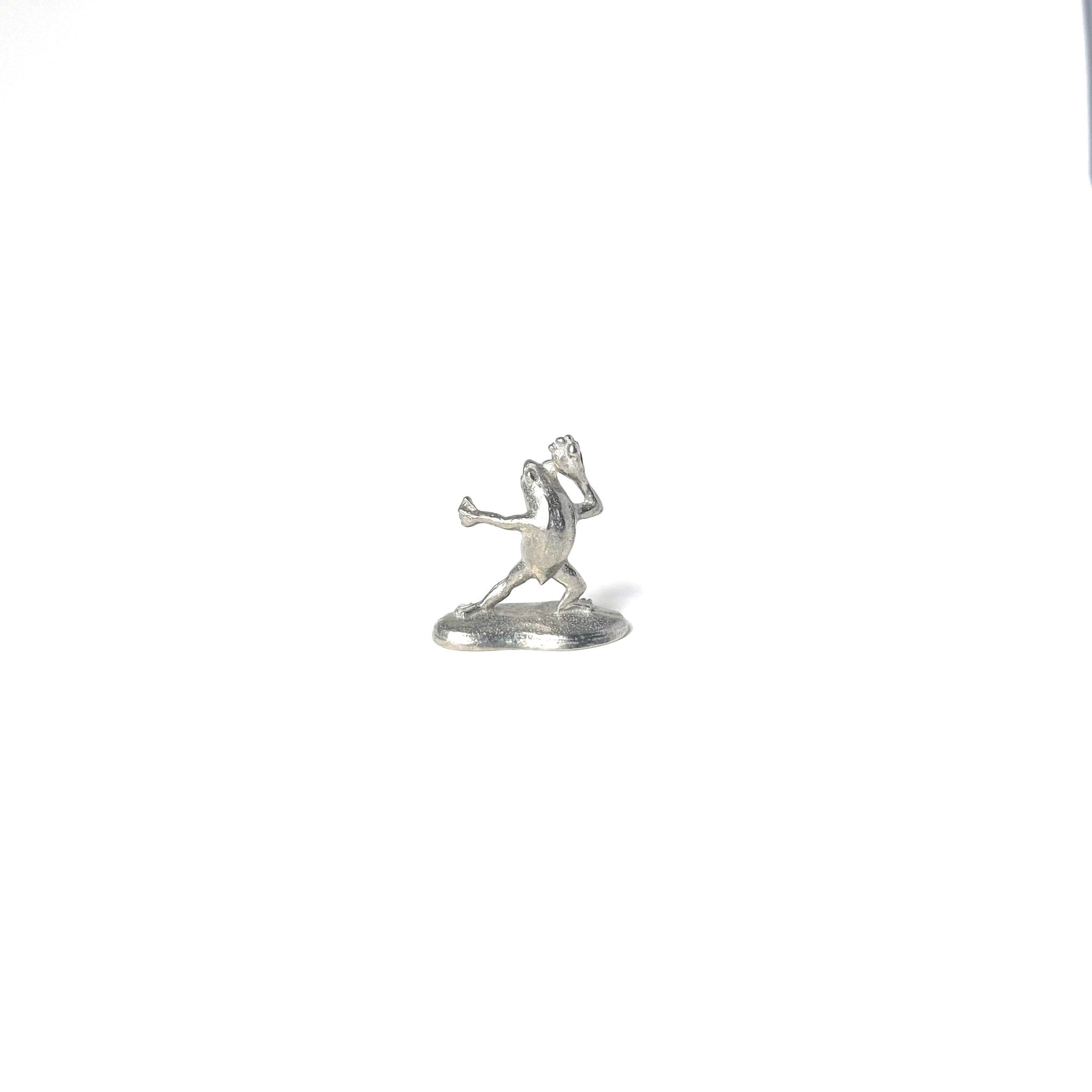 Pewter incense holder shaped like a frog from the Chōjū-giga scrolls, holding incense in a dynamic pose on a white background.