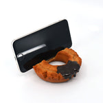 Phone resting securely in a realistic chocolate-glazed donut stand, designed to resemble a half-bitten old-fashioned donut with a glossy topping.