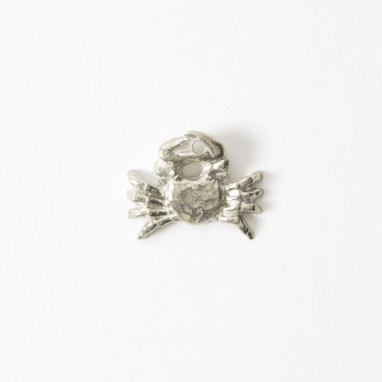 Close-up of a handcrafted silver crab-shaped incense holder made of pewter, placed on a white background.