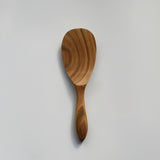 Sakura wood round rice paddle with curved handle, smooth carved bowl, and natural wood grain on a white background