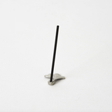 Ginkgo leaf-shaped pewter incense holder with a stick of incense placed upright, photographed on a white background.