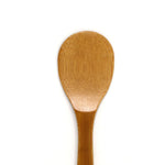 Close-up of a handcrafted Japanese bamboo rice paddle (shamoji) with a smooth finish, designed for non-stick cookware and perfect for serving or mixing steamed rice.