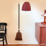 Shuro broom standing against a wall with a Harimi dustpan in a room setting.