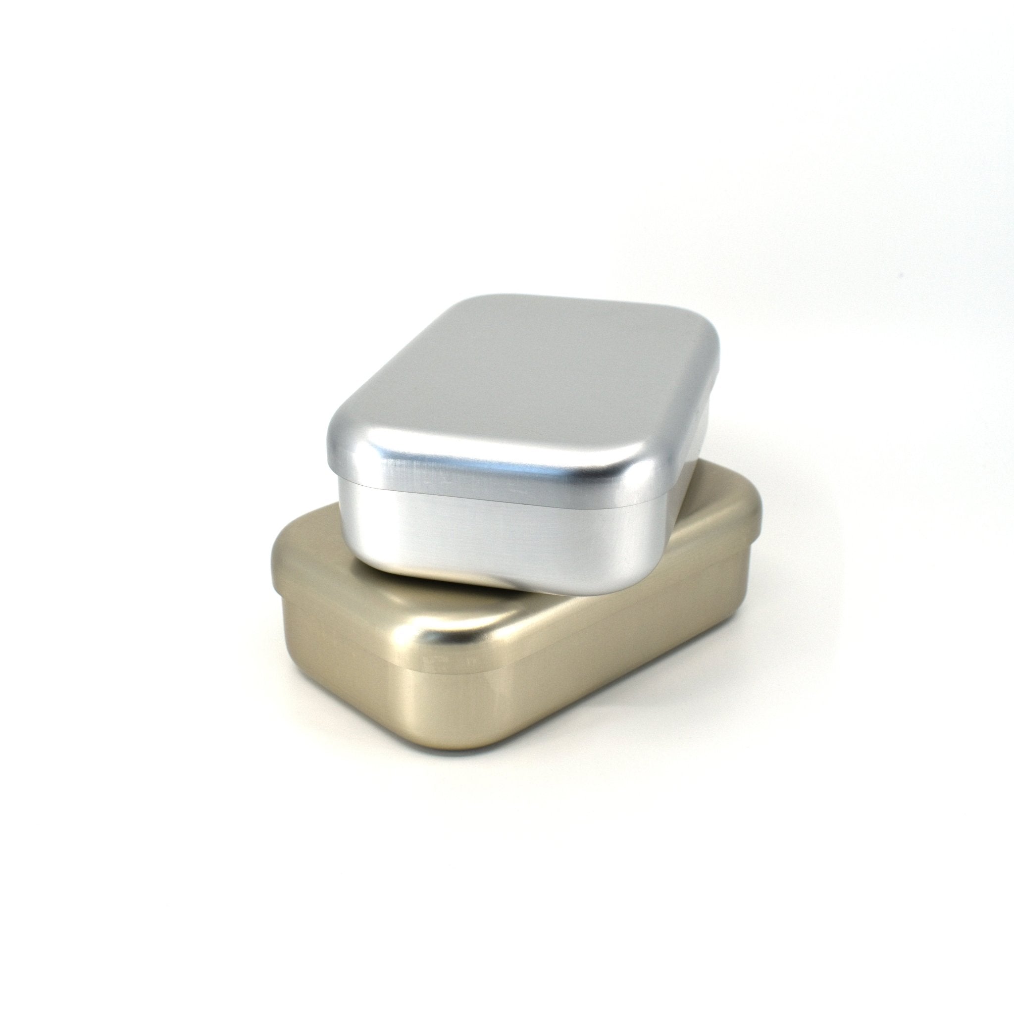 Two minimalist aluminum bento boxes stacked on top of each other, featuring sleek silver and champagne gold finishes against a white background.