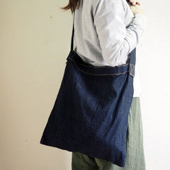 Woman wearing a minimalist Japanese denim shoulder bag with slim profile and hidden inner pockets, ideal for everyday carry