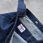 Close-up of Japanese denim shoulder bag interior showing pocket stitching, snap closure, and Three Lake Japan brand label