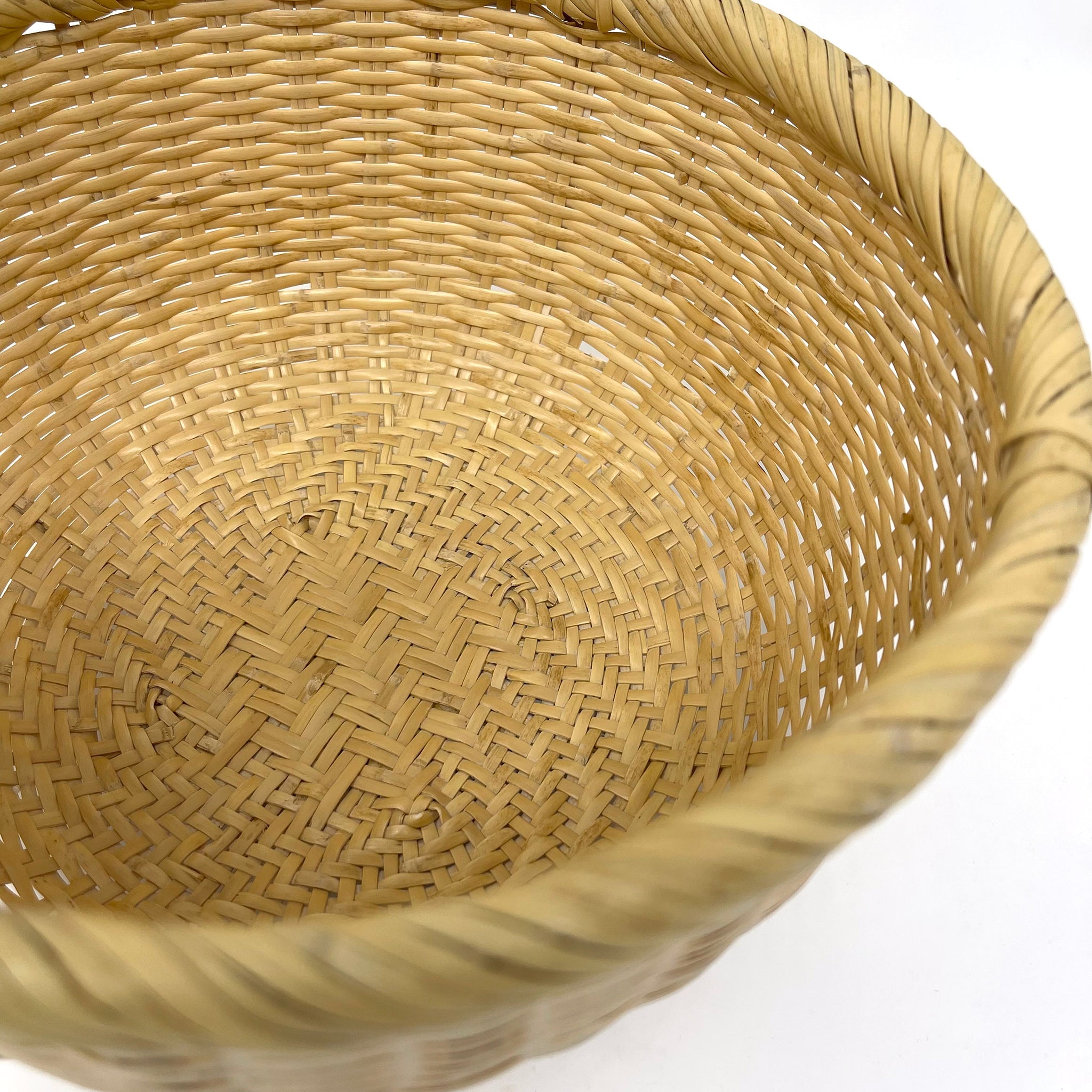 Close-up of the interior weave pattern and rim of a traditional Japanese bamboo basket, showing natural texture and artisan craftsmanship