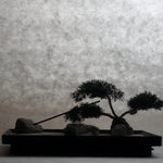 Side view silhouette of Karesansui Zen Garden Incense Holder with bonsai tree and stones.