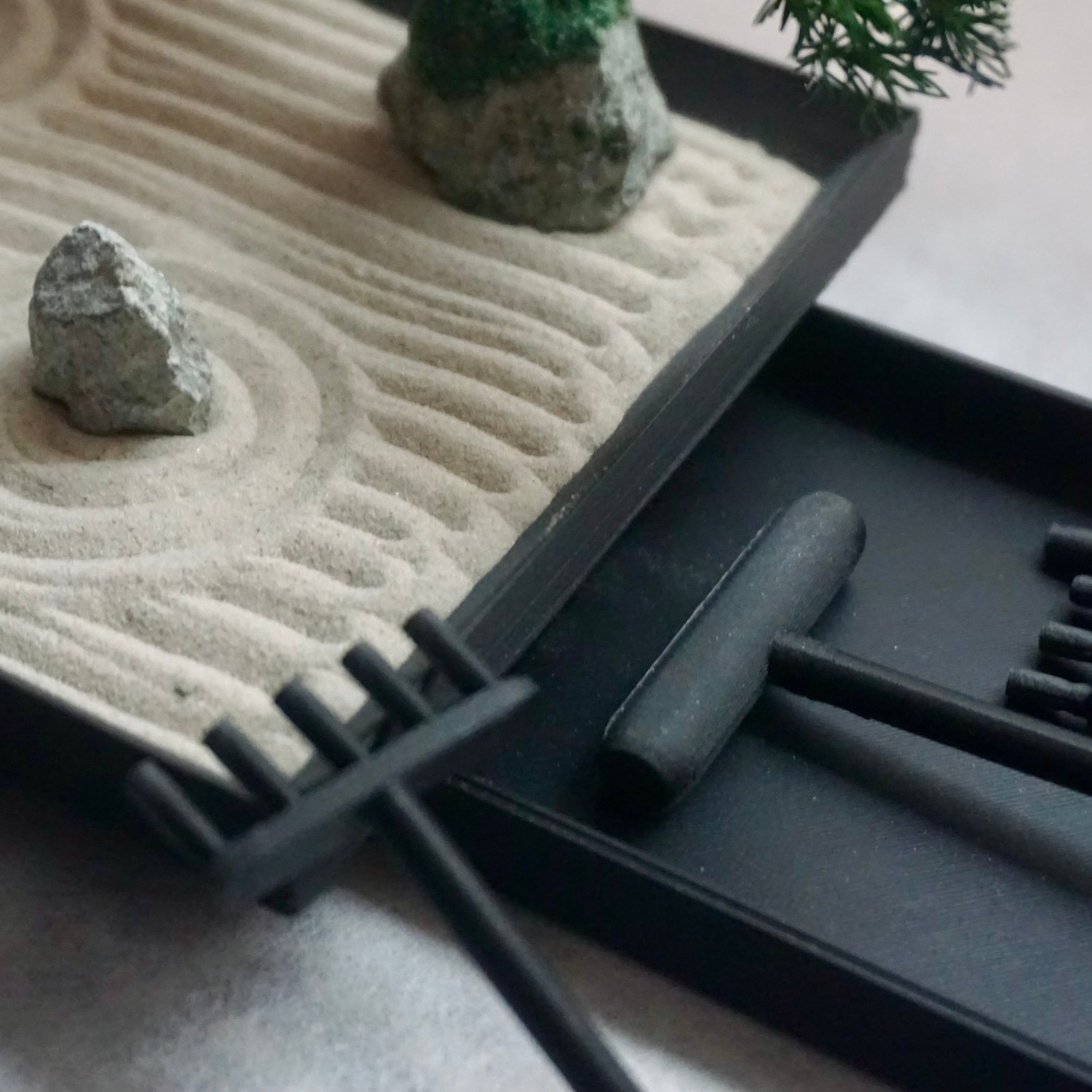 Close-up of miniature Karesansui Zen Garden Incense Holder showing raked sand, stones, and bamboo rakes.