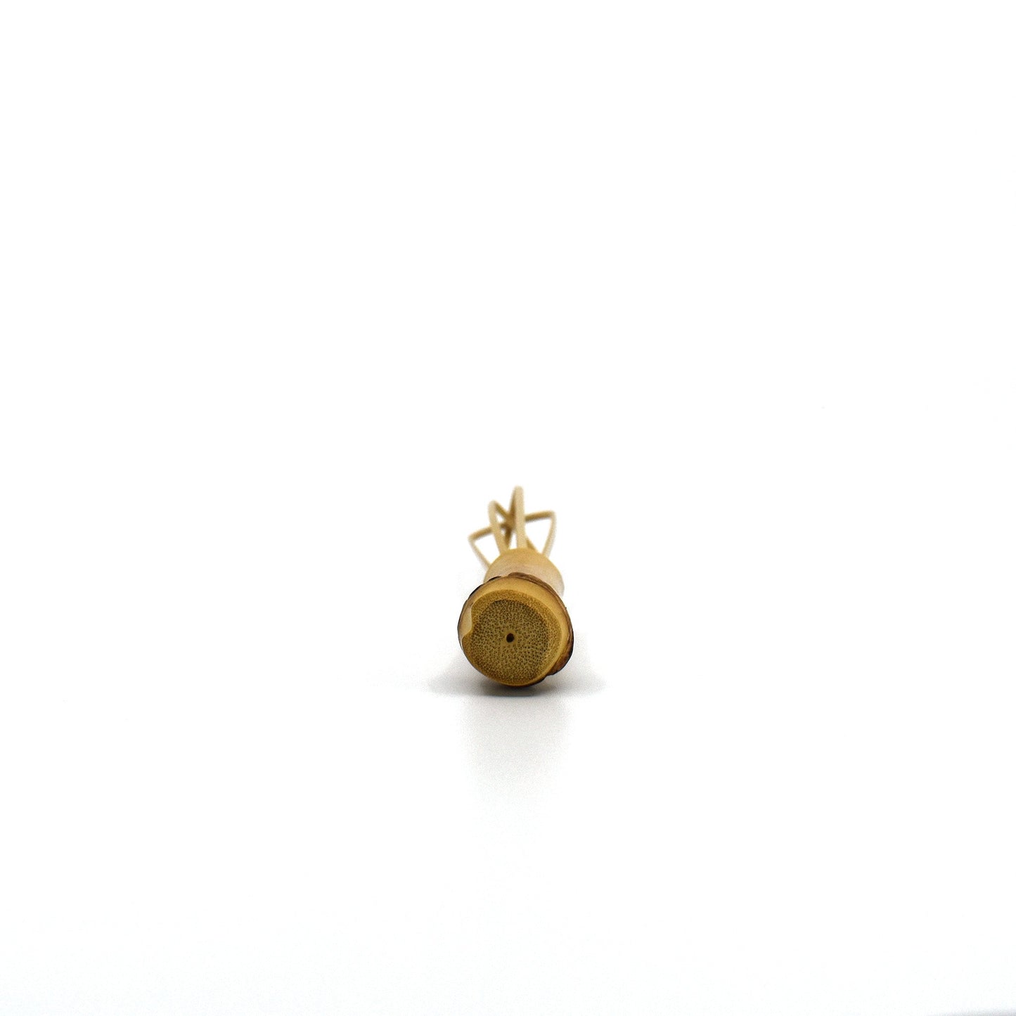Bottom view of a handcrafted mini bamboo whisk, highlighting its natural bamboo cross-section and curved prongs, used in Japanese cooking and tea preparation.