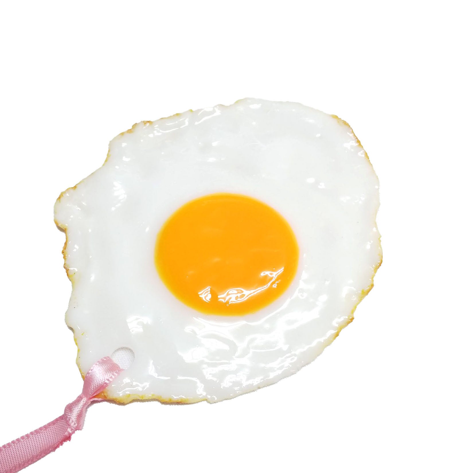Close-up of a hyper-realistic sunny side up egg bookmark with glossy yolk and white, featuring a pink ribbon loop for easy use.