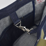 Close-up of interior of Japanese denim tote showing silver snap hook clasp, pocket stitching, and high-quality selvage fabric lining