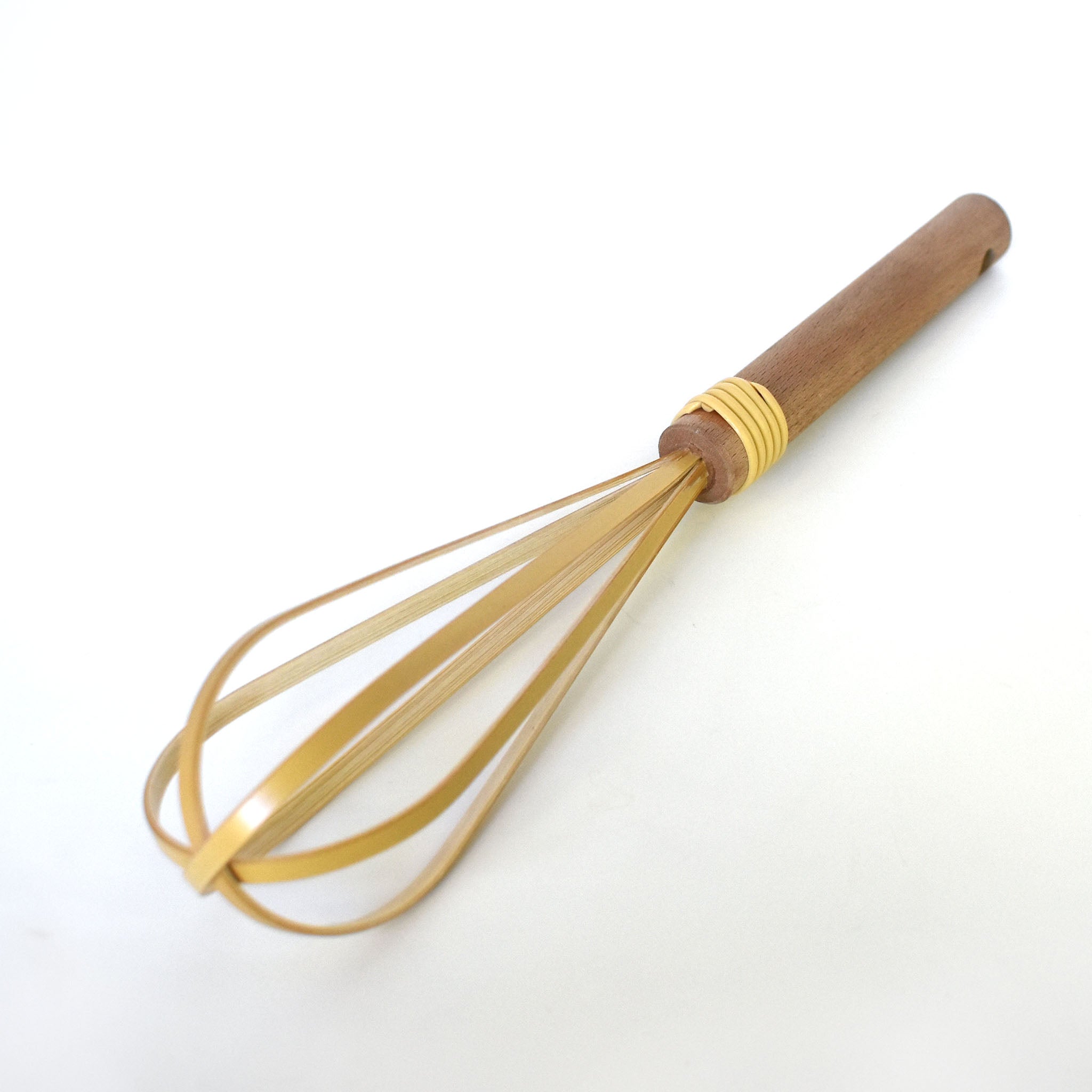 Angled view of a traditional Japanese rice washing whisk made of split bamboo and wood handle, resting on a white background.