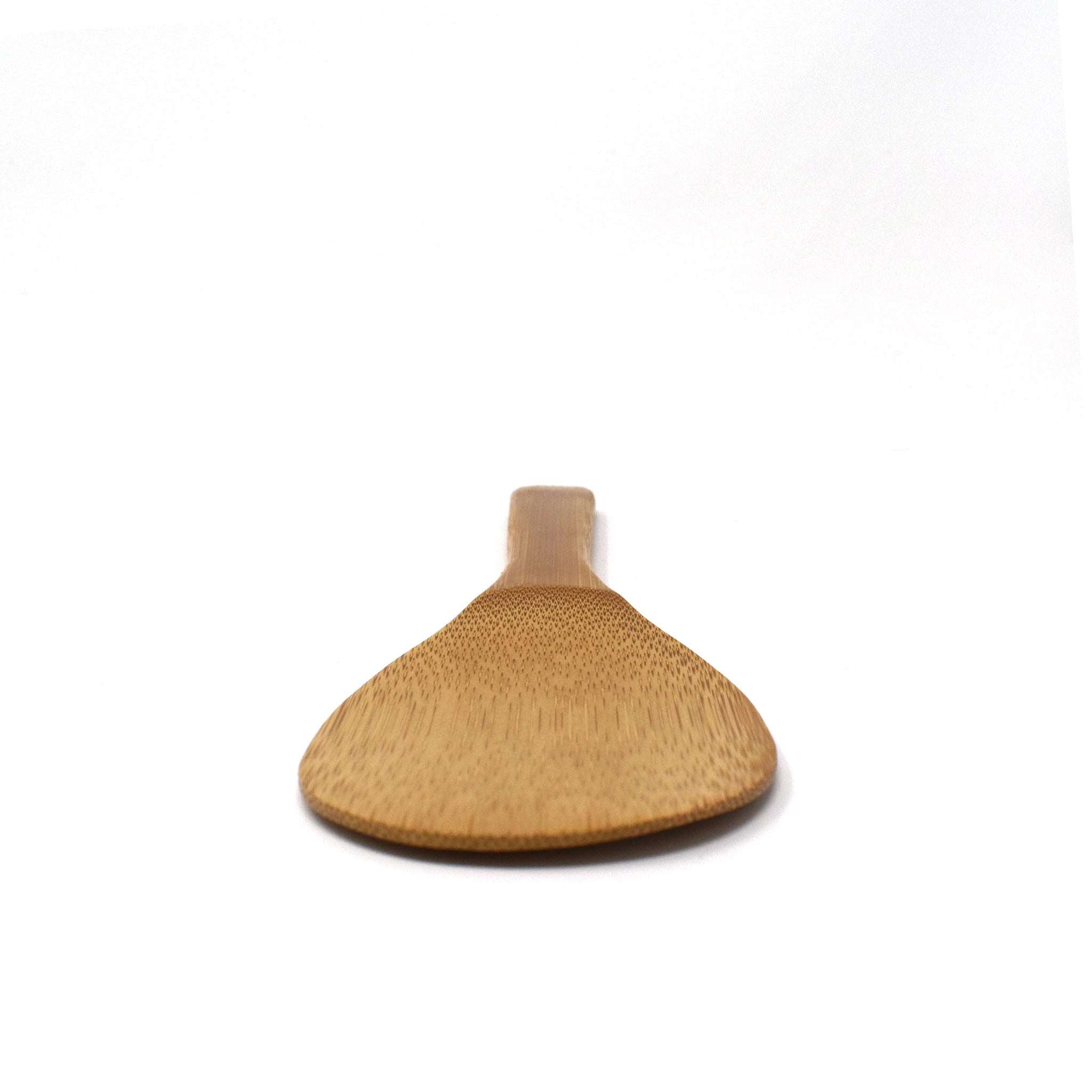 Close-up front view of a Japanese bamboo rice paddle (shamoji), highlighting the smooth, flat surface used for scooping and serving rice without sticking.