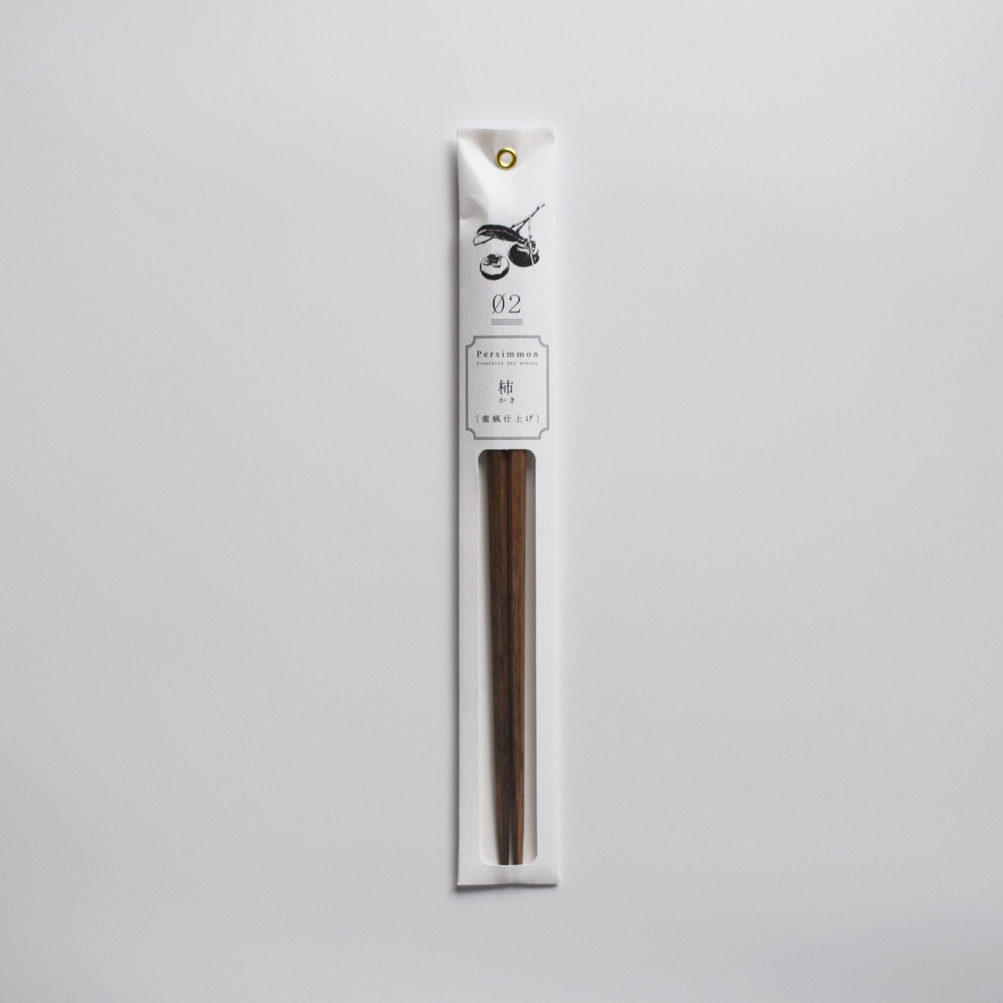 Persimmon wood chopsticks in minimalist white paper packaging with botanical illustration