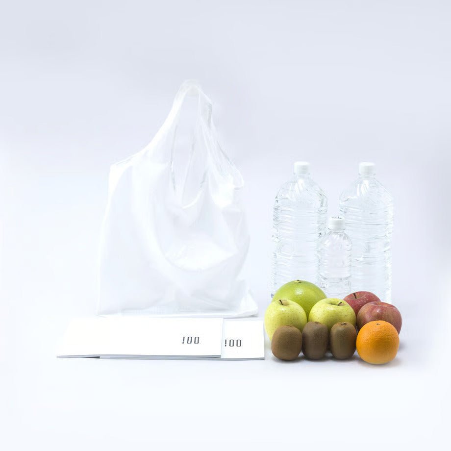 Cocoon Eco Bag fully unfolded and filled with groceries—fruits and large water bottles. Showcases its impressive strength and capacity despite its compact, lightweight design.