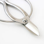 Close-up of Hidehisa stainless steel floral shears highlighting the sharp blade edge and engraved Japanese characters on the polished handle.
