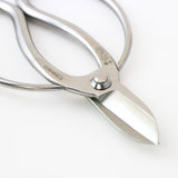 Close-up of Hidehisa stainless steel floral shears highlighting the sharp blade edge and engraved Japanese characters on the polished handle.