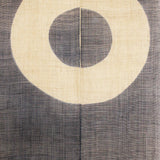 Close-up of Janome noren curtain featuring concentric circle motif in natural and charcoal tones, traditional Japanese fabric panel.