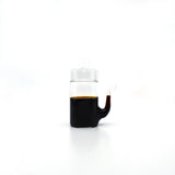 Japanese glass soy sauce dispenser with smooth drip-free spout, filled with soy sauce.