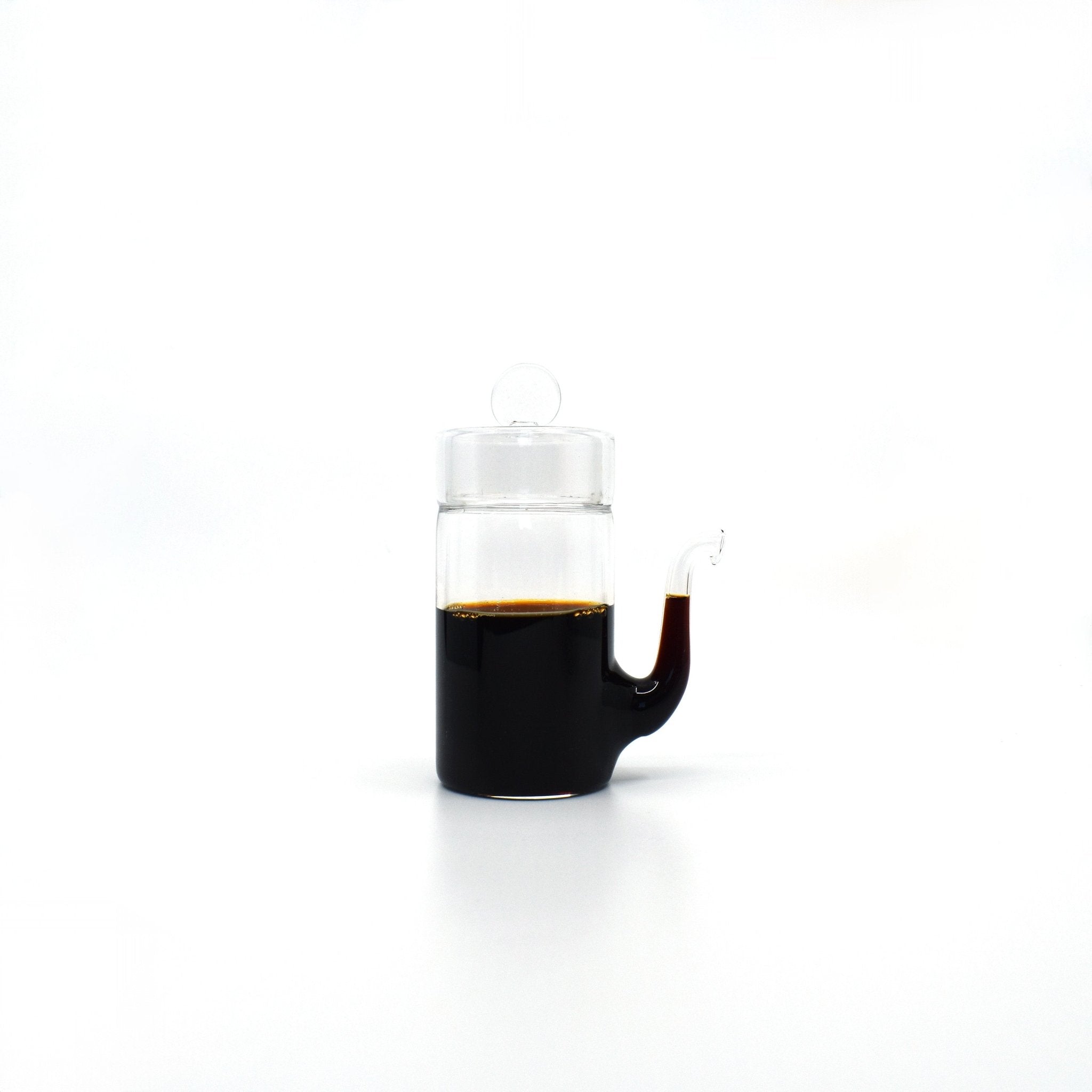 Japanese glass soy sauce dispenser with smooth drip-free spout, filled with soy sauce.