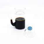 Japanese smooth pour glass soy sauce dispenser filled with soy sauce, shown with removable blue lid.