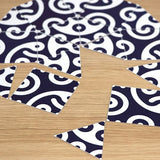 Close-up of a puzzle featuring traditional Japanese indigo and white wave pattern pieces spread across a wooden surface.