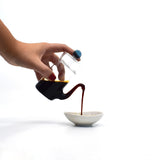 Japanese smooth pour glass soy sauce dispenser pouring soy sauce into small dish, drip-free design.