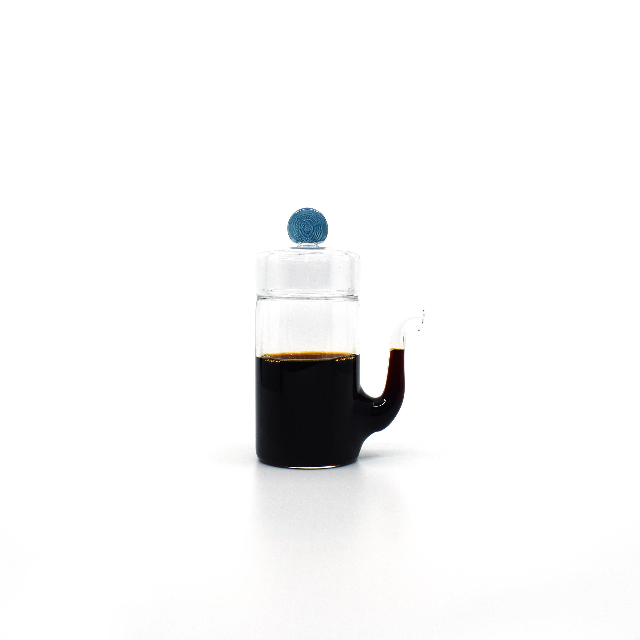 Front view of Japanese smooth pour glass soy sauce dispenser with drip-free spout and blue lid, filled with soy sauce.