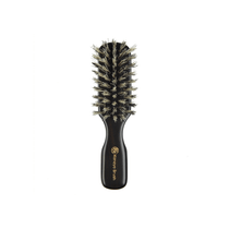 A compact travel-sized natural bristle hairbrush from Kanaya Brush with a dark wooden handle engraved in gold. The soft boar bristles are densely packed in a rounded rectangular shape, designed to gently detangle hair, add shine, and distribute natural oils while on the go. Ideal for maintaining hair health during travel.