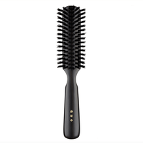 Japanese round hair brush featuring firm black natural bristles and a polished dark wood handle, crafted for smooth detangling and everyday grooming.