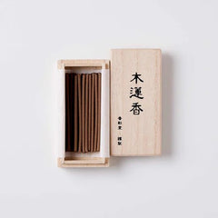 Open box of Koto no Kou Magnolia Incense showing neatly arranged brown incense sticks inside a light wooden case with Japanese calligraphy on the lid