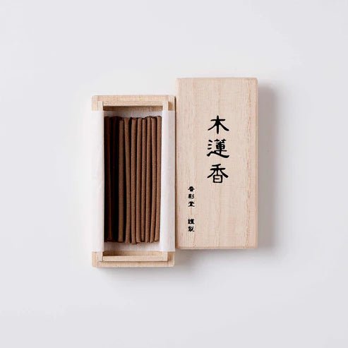 Open box of Koto no Kou Magnolia Incense showing neatly arranged brown incense sticks inside a light wooden case with Japanese calligraphy on the lid