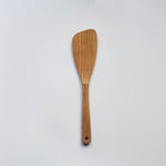 Sakura wood angled spatula with curved paddle shape, hanging hole, and natural wood grain on a white background
