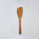 Sakura wood angled spatula with curved paddle shape, hanging hole, and natural wood grain on a white background