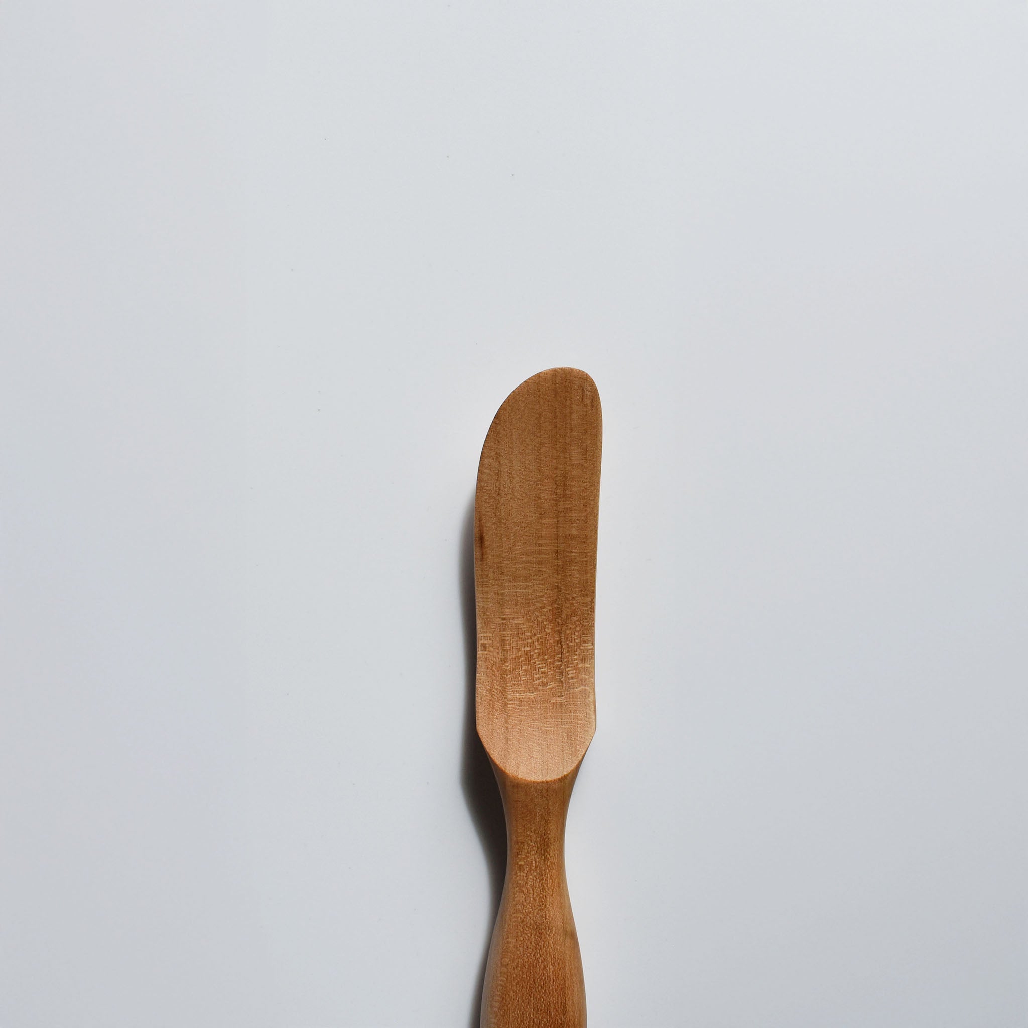 Close-up of the Sakura wood butter knife showing the smooth spreading blade and natural wood grain
