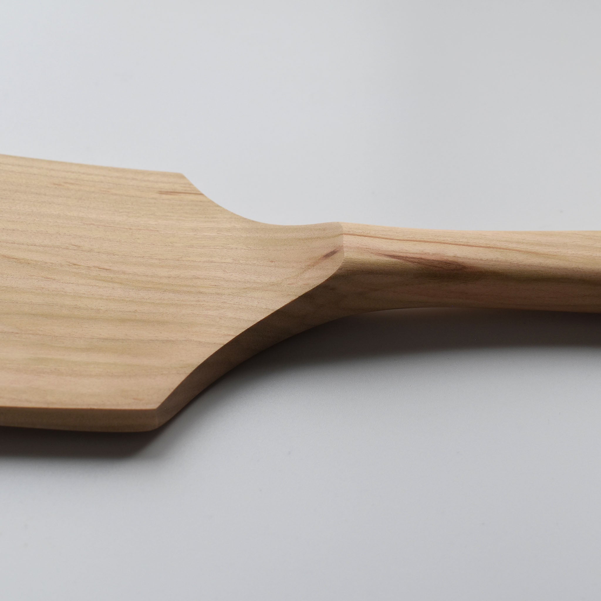 Close-up of the Sakura wood flat spatula showing the carved handle transition and natural wood grain