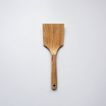 Sakura wood flat spatula with wide paddle shape and natural wood grain on a white background