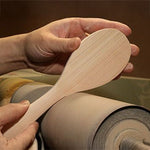 Sakura wood rice paddle being hand-finished to show the natural grain and smooth carved surface
