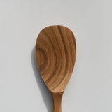Close-up of the Sakura wood round rice paddle showing the carved paddle head and natural wood grain