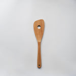 Sakura wood slotted spatula with hanging hole and natural wood grain on a white background