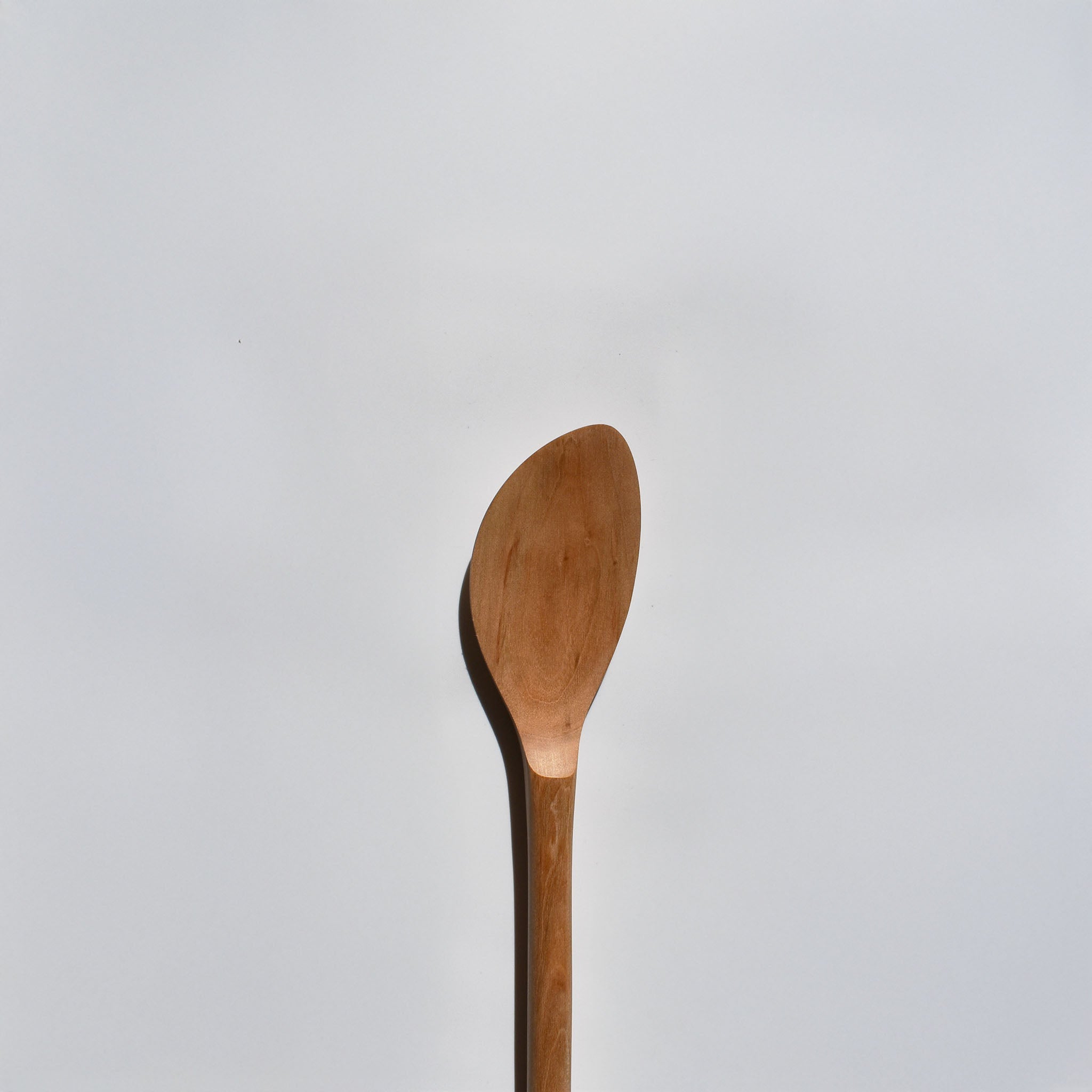 Close-up of the Sakura wood soup spatula showing the smooth carved bowl and natural wood grain