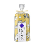 Rolled yellow kitchen cloth with playful dog illustrations, packaged in a clear plastic wrap tied with a raffia ribbon and labeled in Japanese.