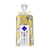 Rolled yellow kitchen cloth with playful dog illustrations, packaged in a clear plastic wrap tied with a raffia ribbon and labeled in Japanese.