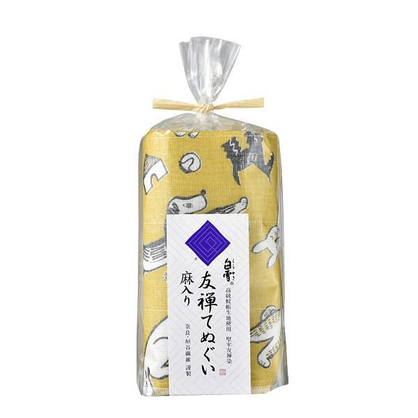 Rolled yellow kitchen cloth with playful dog illustrations, packaged in a clear plastic wrap tied with a raffia ribbon and labeled in Japanese.