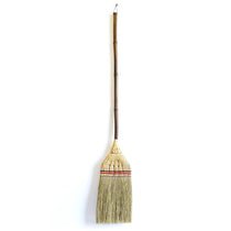 Full view of the Shirokiya Denbei Edo Broom with a premium long handle, featuring intricate straw weaving, red and black decorative bands, and a dark natural bamboo shaft, photographed against a clean white background.