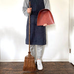 Handmade Shuro broom sweeping a wooden floor, gentle and effective on delicate surfaces like tatami or hardwood.